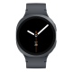 Samsung Galaxy Watch 8 in graphite color lying flat with silicone strap extended, showing the minimalist analog clock face with white hands.